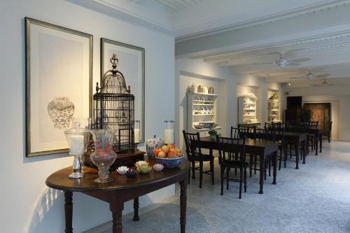 清迈马卡酒店的一间设有桌子的用餐室和墙上的鸟笼