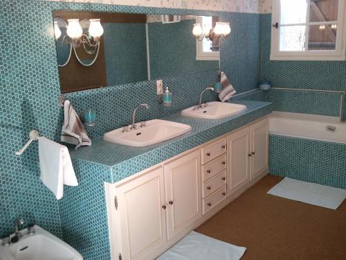 绍莱马斯杜特意松住宿加早餐旅馆的浴室设有2个水槽、镜子和浴缸。