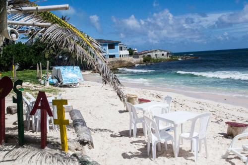 圣安德烈斯Ohana Lodging的沙滩上,有白色的椅子和海洋