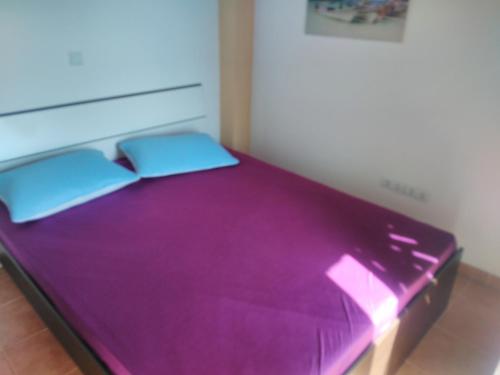 普洛切Apartments Bogunovic的一张紫色床,上面有两个枕头