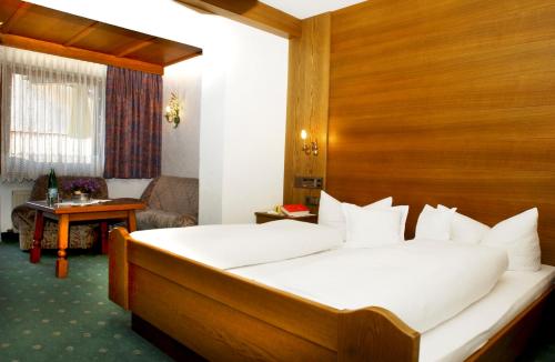 蒂罗尔-泽费尔德Hotel Garni Dietrich的一间卧室配有一张带木制床头板的床