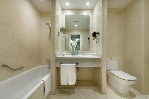 大桑卢卡尔桑卢卡尔大酒店的带浴缸、盥洗盆和卫生间的浴室