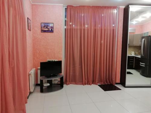 Petropavlovskaya BorshchagovkaТаунхаус 99的客厅配有橙色窗帘和电视