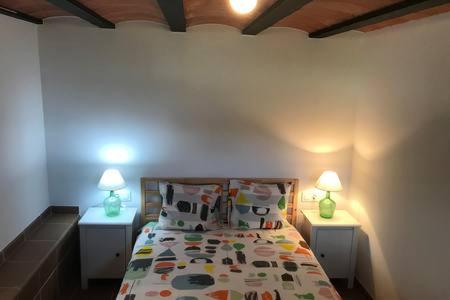 卡内·德·玛尔Casita en plena naturaleza con piscina y wifi gratis的一间卧室配有一张床,两盏台灯放在两张桌子上