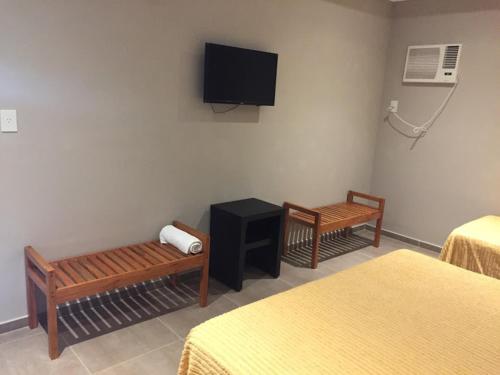 贝拉维斯塔Aires de Río的客房设有两张床和一台墙上的电视。