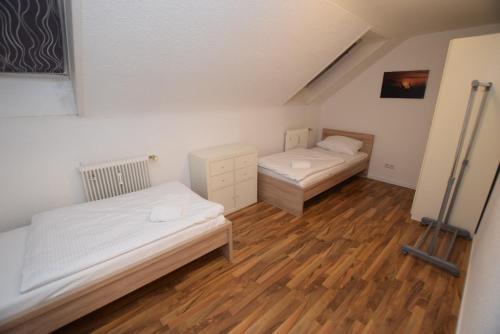 奥斯特菲尔登Apartment Ostfildern-Nellingen II的铺有木地板的小客房内的两张床