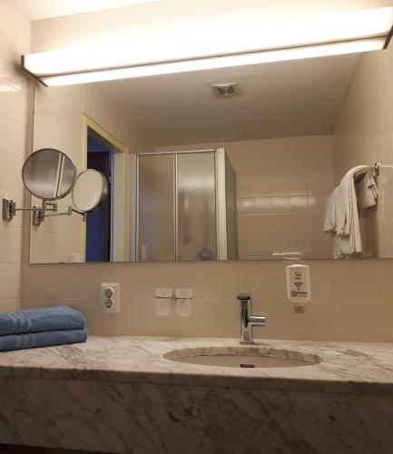 玛丽亚阿尔姆马可·波罗家庭运动酒店的一间带水槽和大镜子的浴室