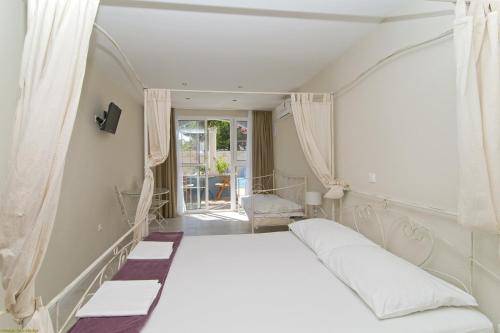 图彻皮Villa Bougenvilia Tomas的窗户客房内的一张白色床