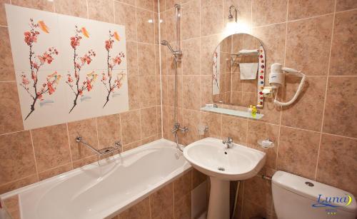 基希讷乌月神酒店的一间带水槽、浴缸和卫生间的浴室