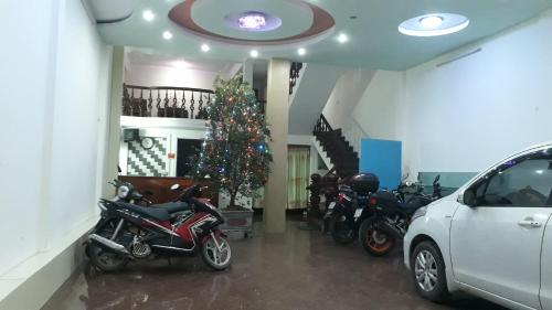 Hoàn GiápNhà nghỉ Book的一间有摩托车的房间,里面有一棵圣诞树