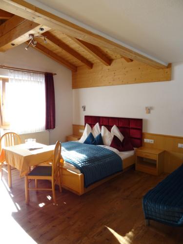 齐勒河谷采尔玫瑰园餐厅酒店的卧室配有一张床和一张桌子