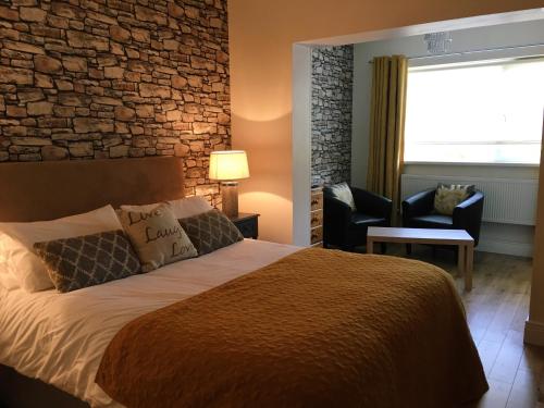 亚达尔Abbeyvilla Guesthouse Room Only的一间卧室设有一张床和砖墙