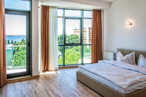 马马亚海滨住宅公寓酒店的一间卧室设有一张床和大窗户