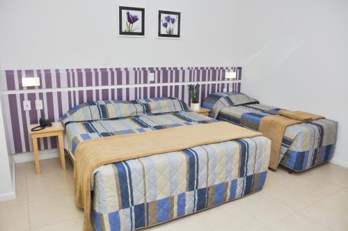 纳韦甘蒂斯BR Suítes Hotel的一间卧室配有两张床和一张带床垫的桌子。