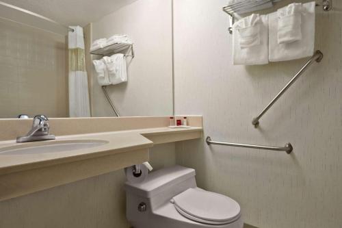 大章克申大章克申华美达酒店的一间带卫生间、水槽和镜子的浴室