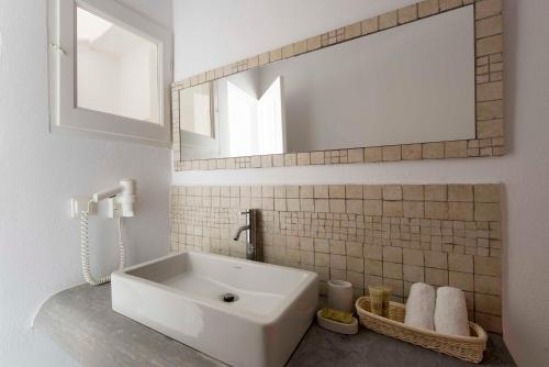 易莫洛林果格纳别墅酒店的浴室设有白色水槽和镜子