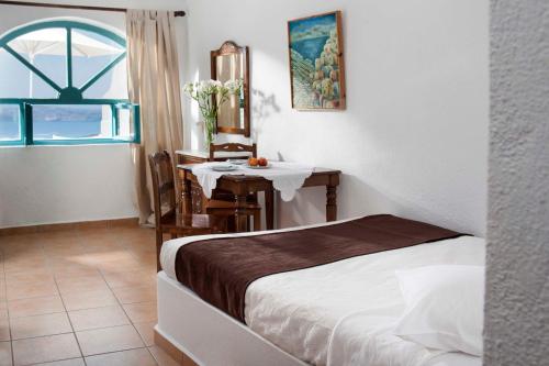 易莫洛林果格纳别墅酒店的卧室配有桌子和一张位于客房内的床
