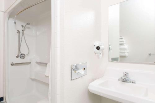 安克雷奇Baymont Inn & Suites by Wyndham Anchorage Airport的白色的浴室设有水槽和镜子