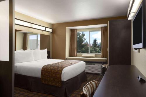 奥德萨Microtel Inn & Suites by Wyndham Odessa TX的酒店客房设有床和窗户。