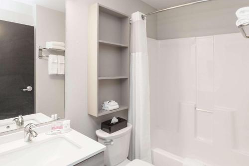 West FargoMicrotel Inn & Suites by Wyndham West Fargo Near Medical Center的浴室配有卫生间、盥洗盆和淋浴。
