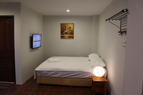 沙湾拿吉avalon residence2的一间卧室配有一张床和一张桌子上的台灯