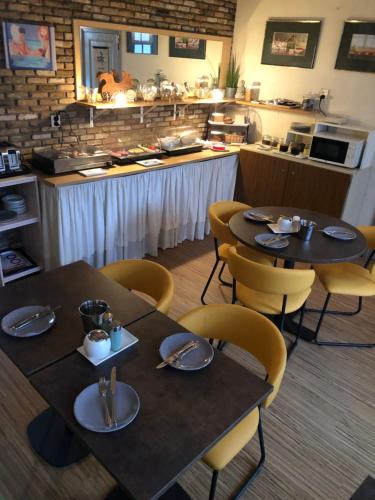 栋堡兹舍尔普旅馆的一间带2张桌子和椅子以及柜台的餐厅