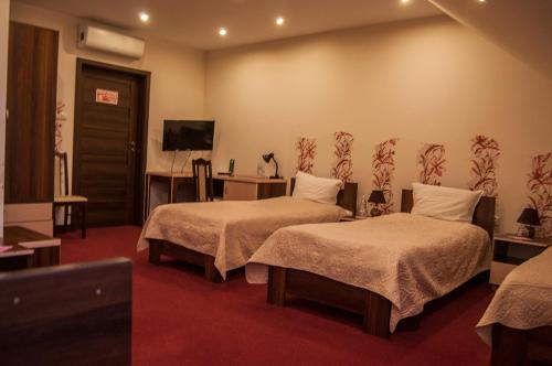 拉多姆Prymus的酒店客房设有两张床和电视。