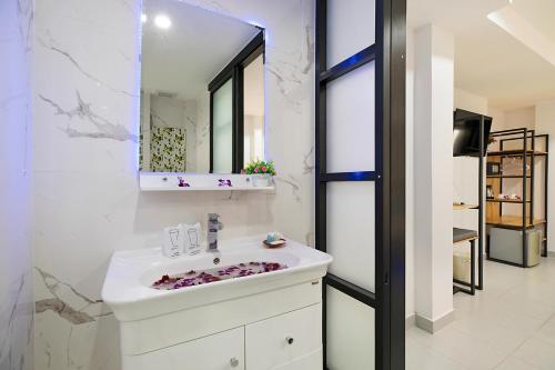 拉迈Colorize Boutique Hotel的浴室设有白色水槽和镜子