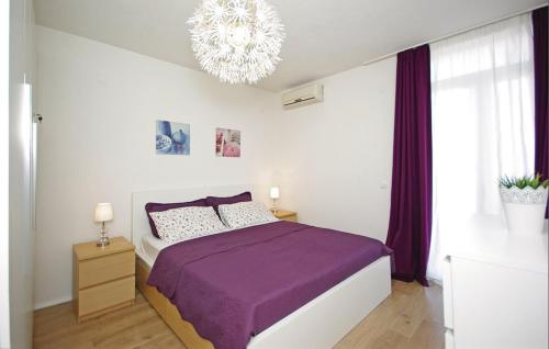 布雷拉Apartment MIVA的一间卧室配有紫色的床和吊灯。