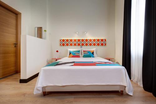 塞萨洛尼基Colors Ladadika Thessaloniki的卧室配有一张带彩色枕头的大型白色床。