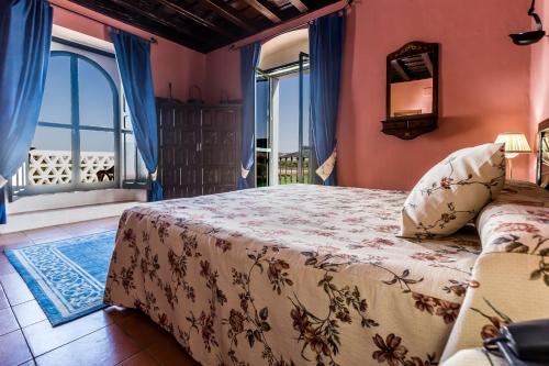 阿尔科斯-德拉弗龙特拉Hacienda el Santiscal的一间卧室设有一张床和一个窗口