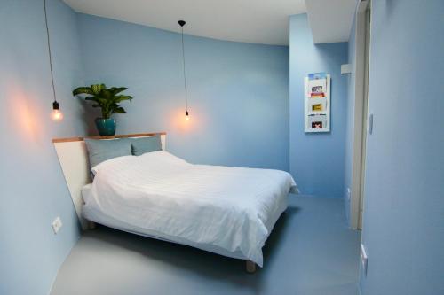 阿姆斯特丹Sailor Suite Coaster Mado的一间拥有蓝色墙壁的卧室和一张带白色床单的床