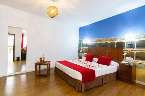 隆达Hotel El Tajo & SPA的一间卧室配有一张带红色枕头的大床