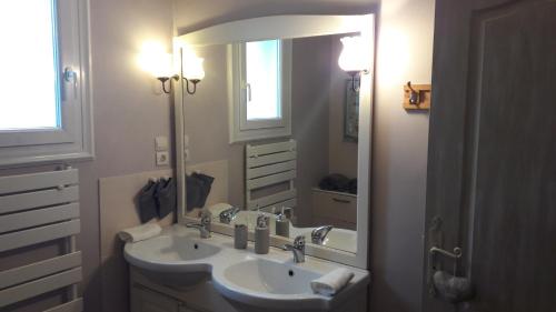 米萨讷chambre d'hôte - La ruche des Bleuets的一间带两个盥洗盆和大镜子的浴室