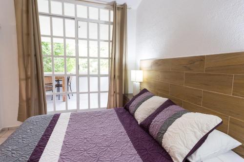 坎昆Quetzal Loft的一间卧室设有一张床和一个大窗户
