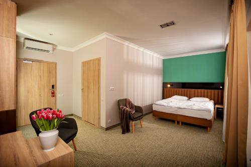 切霍齐内克Akacja Medical Resort的酒店客房带一张床、一张桌子和椅子