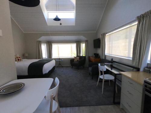 奥阿库尼The Ohakune Central Motels的酒店客房配有一张床、一张书桌和一间厨房。