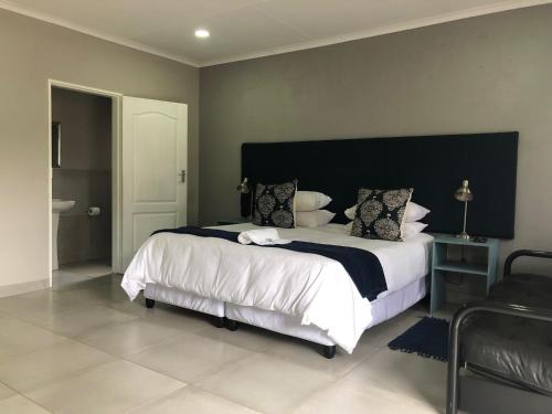莫科帕内Odelia Guest House的一间卧室配有一张大床和黑色床头板