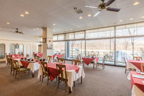 Minamimaki八岳格雷斯酒店度假村的用餐室设有桌椅和窗户。