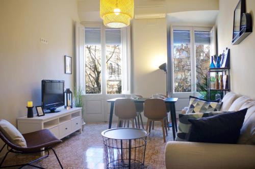 帕拉弗鲁赫尔Apartament en Plaça Nova , Palafrugell的客厅配有沙发和桌子