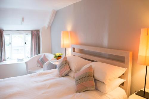 斯内蒂瑟姆The Rose & Crown, Snettisham的一间卧室配有一张带两盏灯的大型白色床。