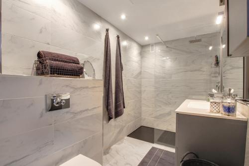 多列毛利诺斯La Nogalera Deluxe Apartment Torremolinos的带淋浴和盥洗盆的白色浴室