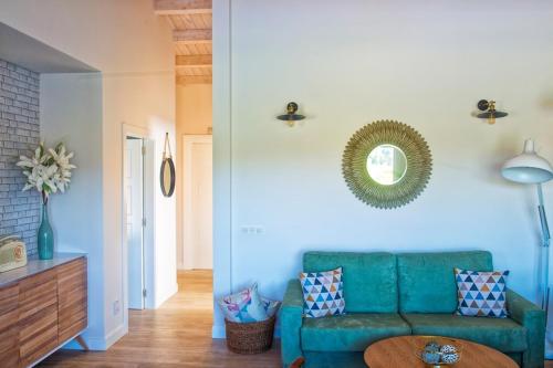RibadumiaA Casa da Pereira的客厅配有绿色沙发和镜子