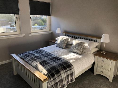 斯特灵Old Police House Causewayhead Stirling的一间卧室设有一张床和两个窗户。