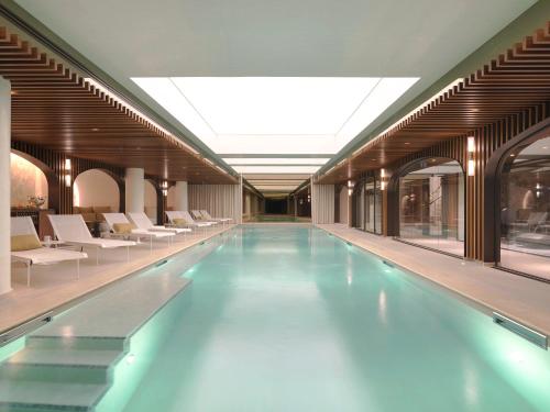 巴黎多布松酒店的一座带白色椅子的建筑中的游泳池