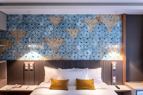 斯特拉斯堡voco Strasbourg Centre - The Garden, an IHG Hotel的一间卧室配有一张蓝色和金色壁纸的床