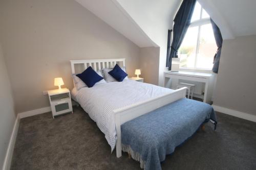 斯图尔特港Strand House 2的卧室配有白色床、蓝色枕头和窗户