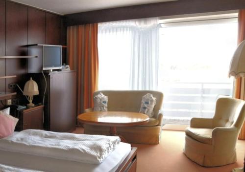 博尔库姆Hotel das Miramar的卧室配有1张床、1张桌子和1把椅子