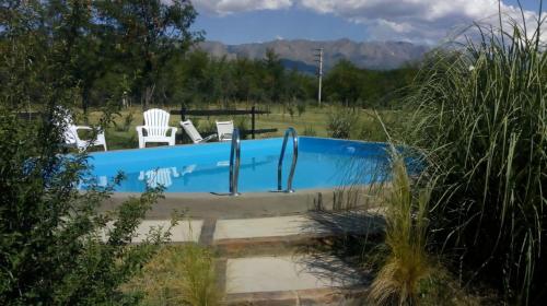 诺诺Las Quimeras的一个带两把白色椅子的游泳池