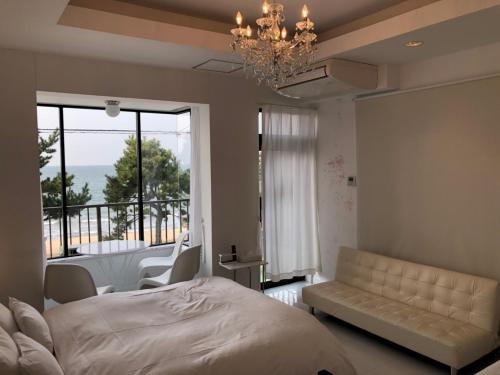 唐津汪洋海上风情度假酒店的一间卧室配有一张床和一张沙发,并设有一个阳台
